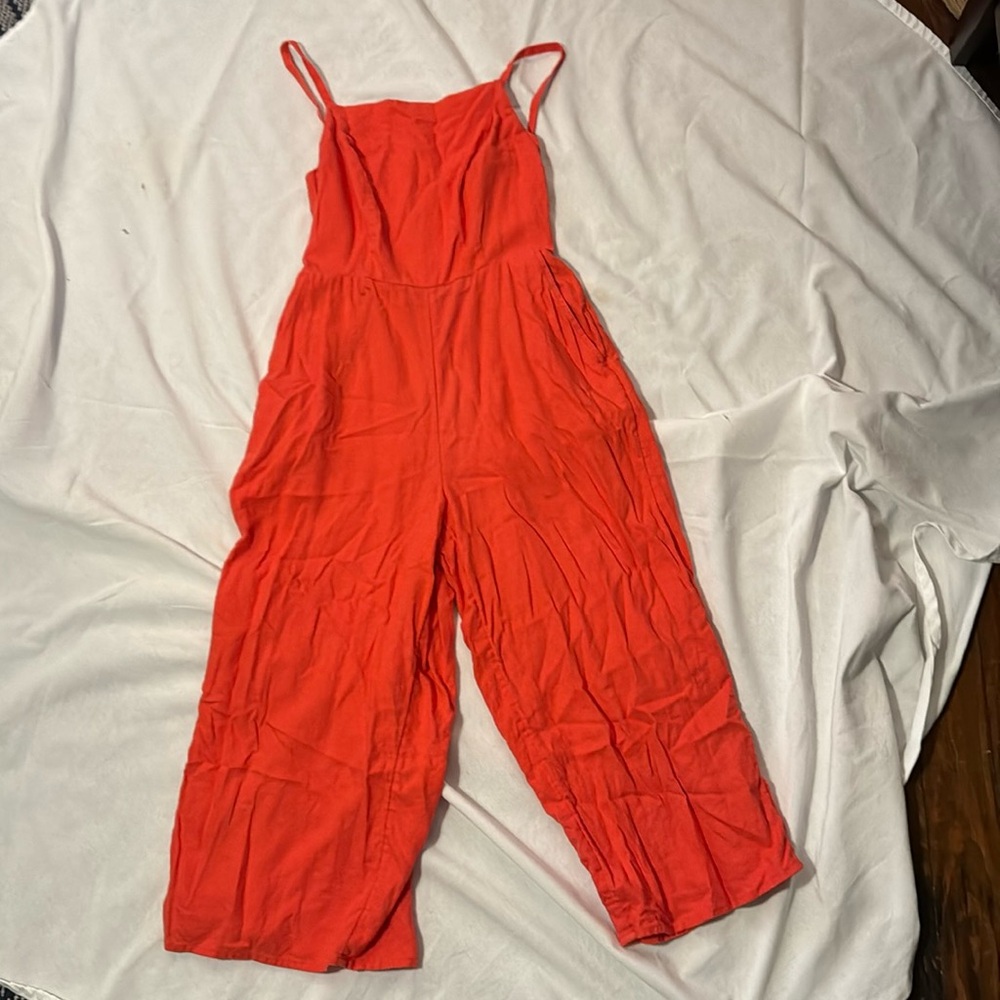 Red linen jumpsuit with pockets.